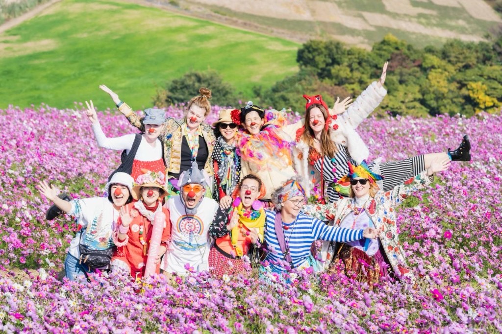 Caroline et un groupe de clowns dans un champ de cosmos